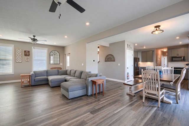 living room featuring ceiling fan and dark hardwood / wood-style floors