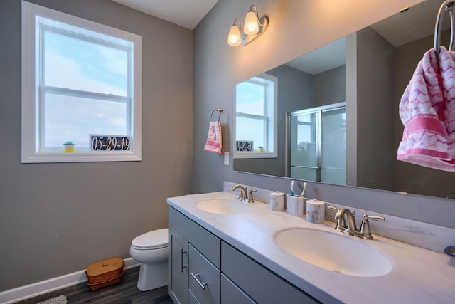 bathroom featuring vanity, hardwood / wood-style floors, an enclosed shower, and toilet