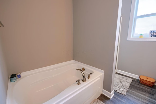 bathroom featuring hardwood / wood-style floors and a bath