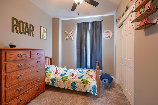 carpeted bedroom with ceiling fan and a closet