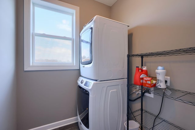 clothes washing area featuring stacked washer and dryer