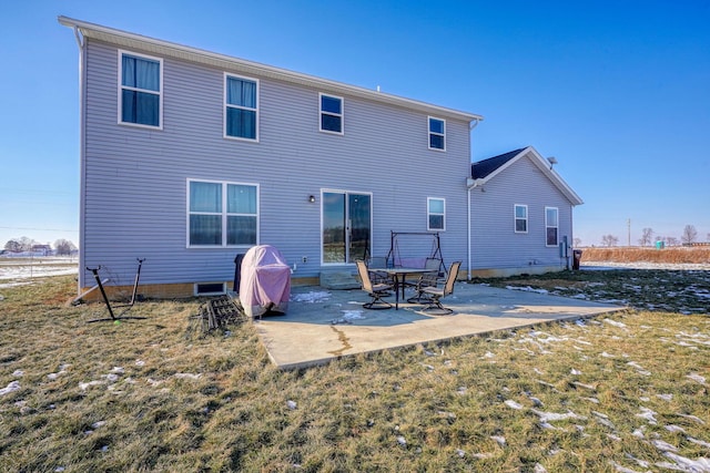 back of property with a yard and a patio