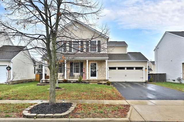 front of property with covered porch, a garage, and a front lawn