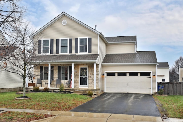 view of front of property with a front yard, a garage, and covered porch