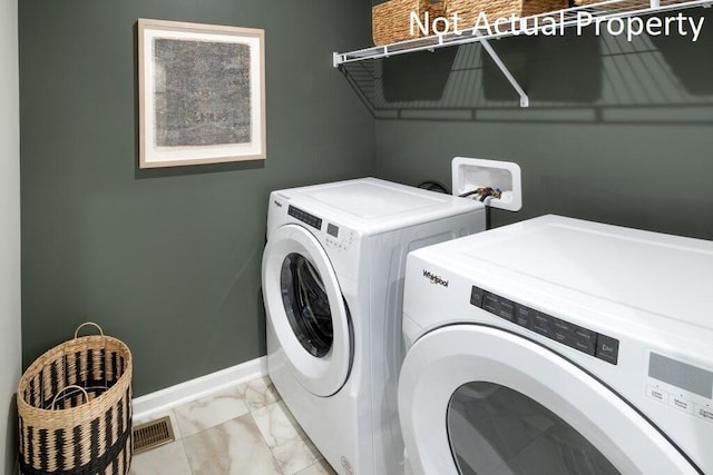 clothes washing area featuring washing machine and dryer, laundry area, visible vents, baseboards, and marble finish floor