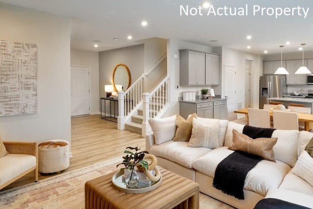 living room with light wood finished floors, stairway, and recessed lighting