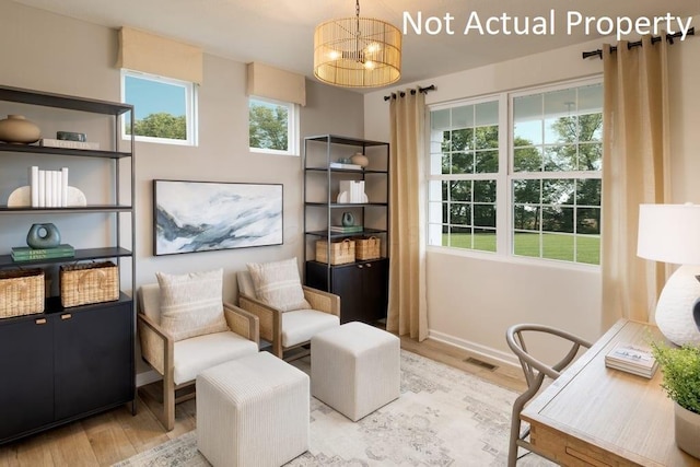 sitting room featuring light wood finished floors, visible vents, a chandelier, and baseboards