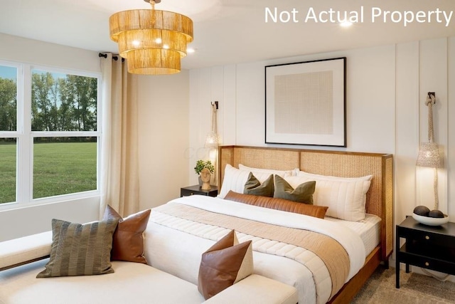 carpeted bedroom with an inviting chandelier