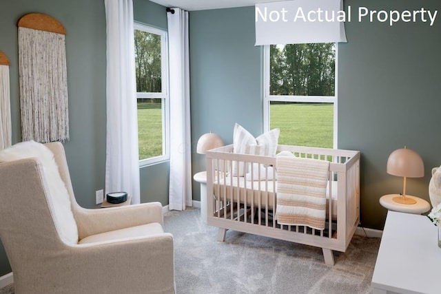 bedroom featuring carpet, a crib, and baseboards