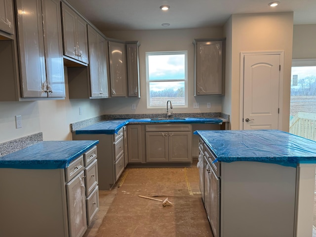 kitchen featuring a kitchen island, recessed lighting, and a sink