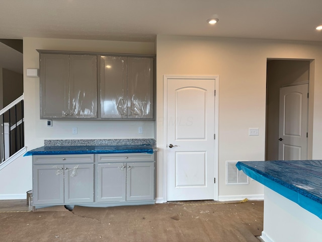 kitchen featuring baseboards, visible vents, dark countertops, gray cabinets, and recessed lighting