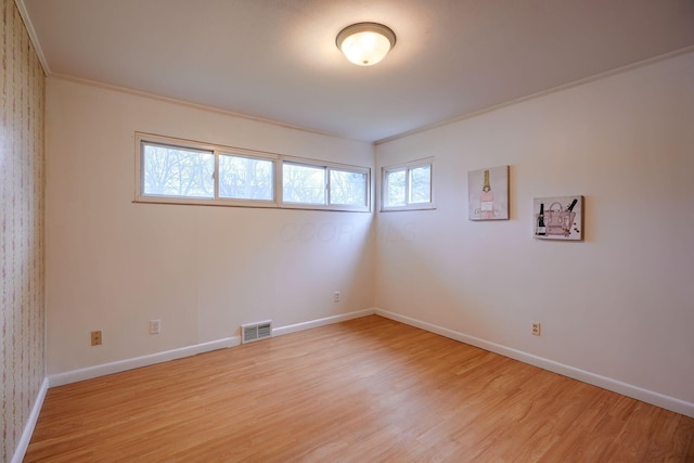 unfurnished room with light hardwood / wood-style floors, plenty of natural light, and ornamental molding