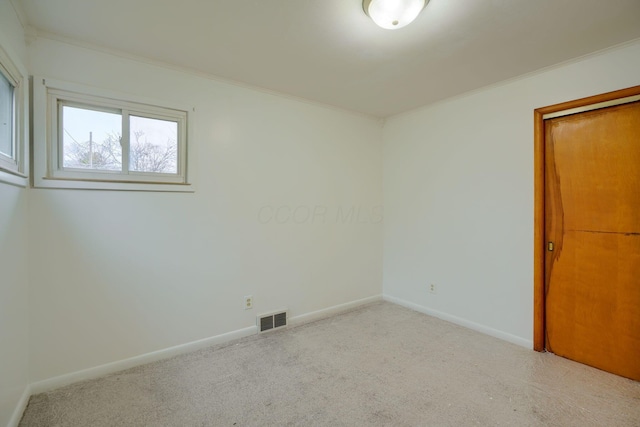 carpeted spare room with crown molding