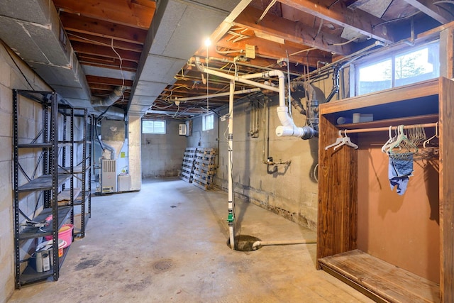 basement featuring a wealth of natural light and heating unit