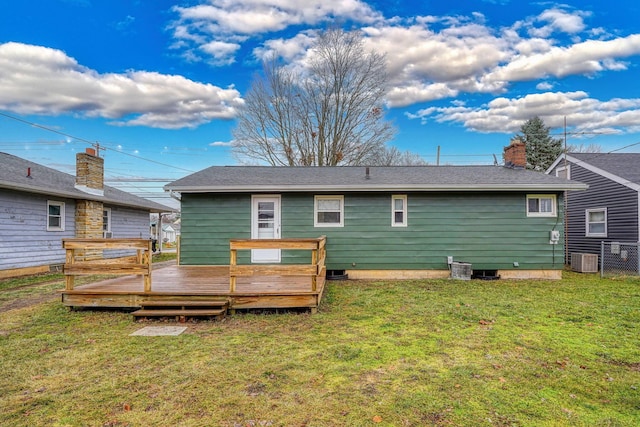 rear view of property featuring central AC, a deck, and a lawn