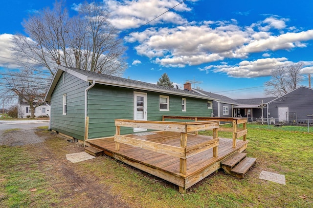 back of property with a lawn and a deck