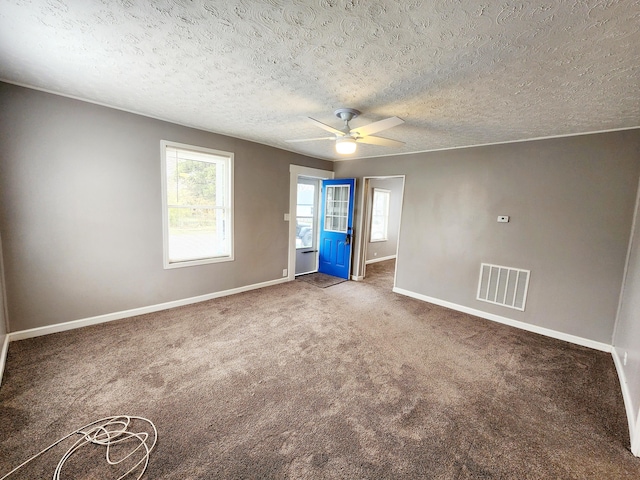 carpeted spare room featuring a textured ceiling and ceiling fan