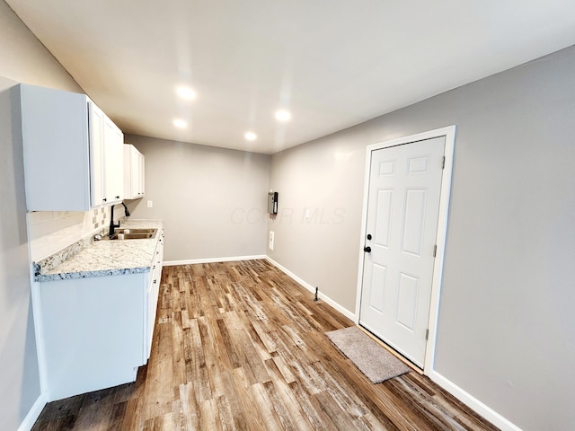 laundry area with light wood-type flooring and sink