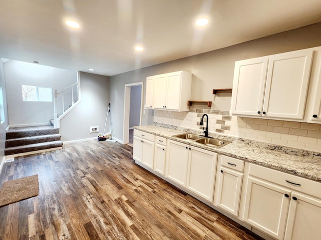 kitchen with white cabinetry, light hardwood / wood-style flooring, tasteful backsplash, and sink