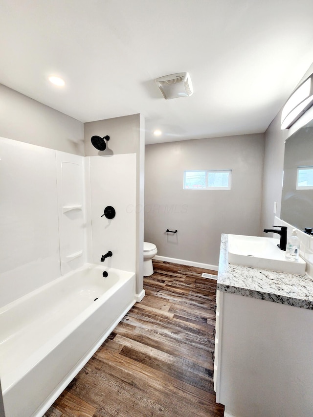 full bathroom with shower / tub combination, vanity, hardwood / wood-style flooring, and toilet