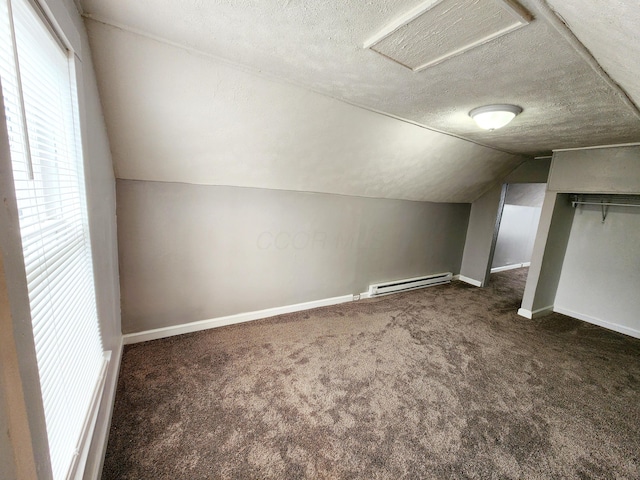 bonus room featuring dark carpet, a textured ceiling, a baseboard radiator, and vaulted ceiling