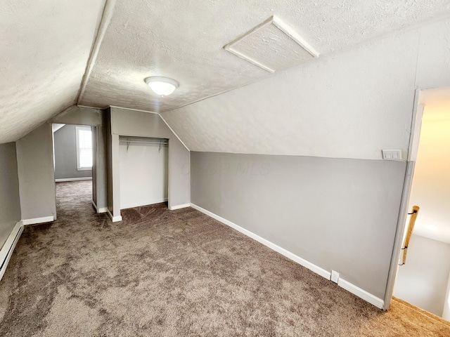 bonus room featuring dark colored carpet, a textured ceiling, and lofted ceiling