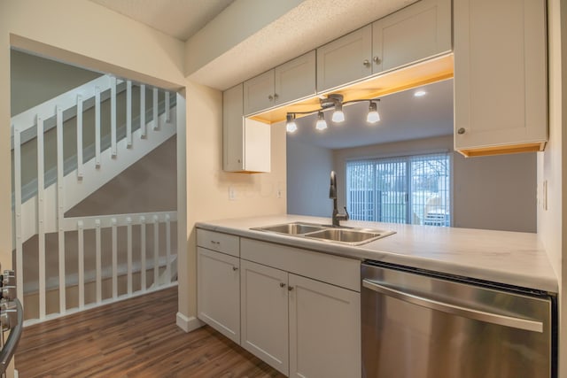 kitchen featuring sink, white cabinetry, stainless steel dishwasher, and dark hardwood / wood-style flooring