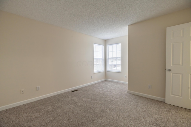 carpeted spare room featuring a textured ceiling