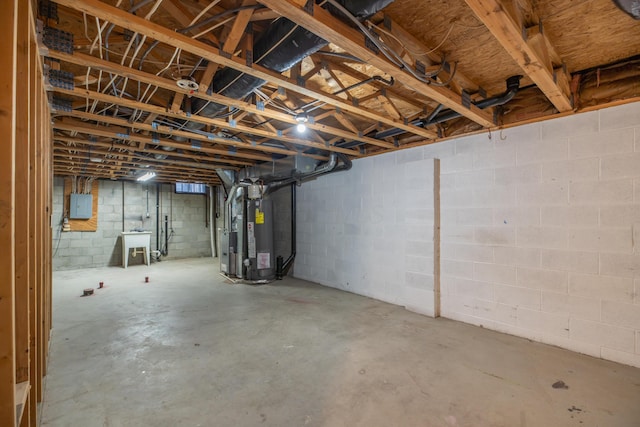 basement featuring sink, electric panel, and water heater