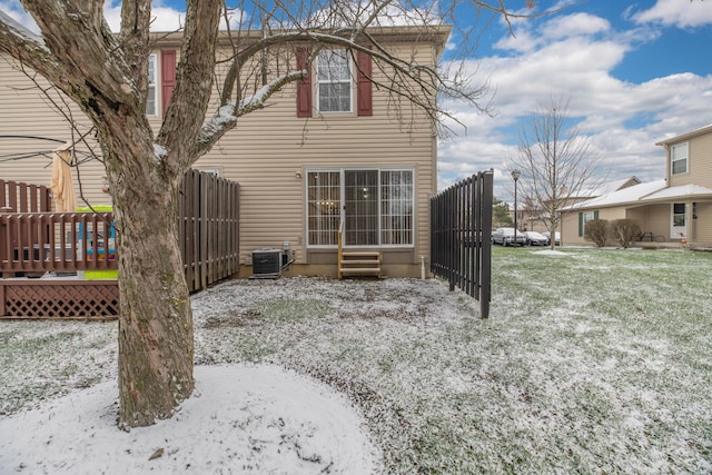 snow covered property featuring a yard and central air condition unit