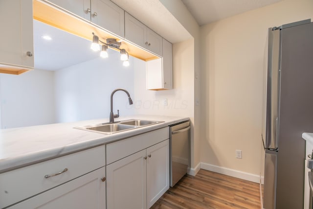 kitchen featuring sink, white cabinetry, appliances with stainless steel finishes, and dark hardwood / wood-style flooring