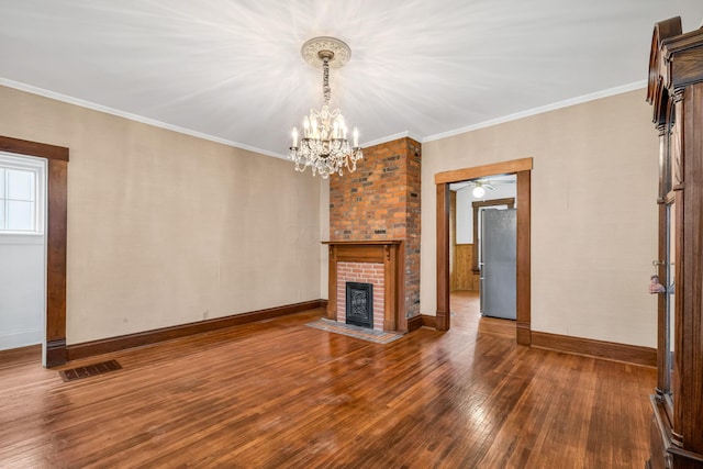 unfurnished living room with crown molding, a fireplace, wood-type flooring, and ceiling fan with notable chandelier