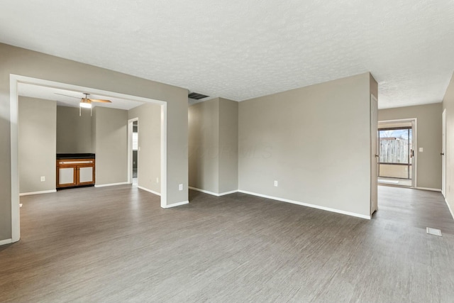 unfurnished room with ceiling fan, wood-type flooring, and a textured ceiling