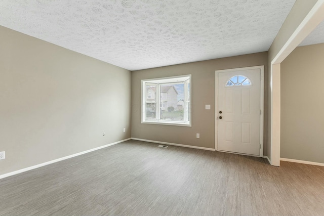 entrance foyer featuring a textured ceiling and light wood-type flooring