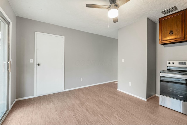 kitchen with a textured ceiling, light hardwood / wood-style flooring, ceiling fan, and stainless steel range with electric cooktop