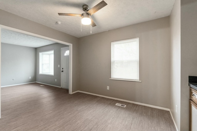 interior space with a textured ceiling, hardwood / wood-style flooring, and ceiling fan