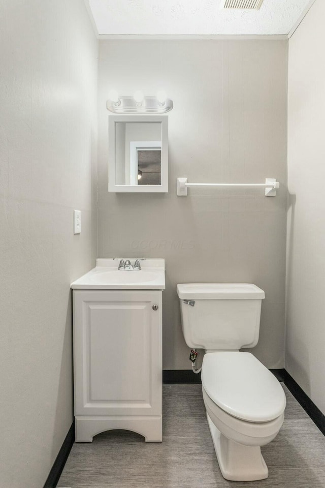 bathroom with vanity, toilet, and wood-type flooring