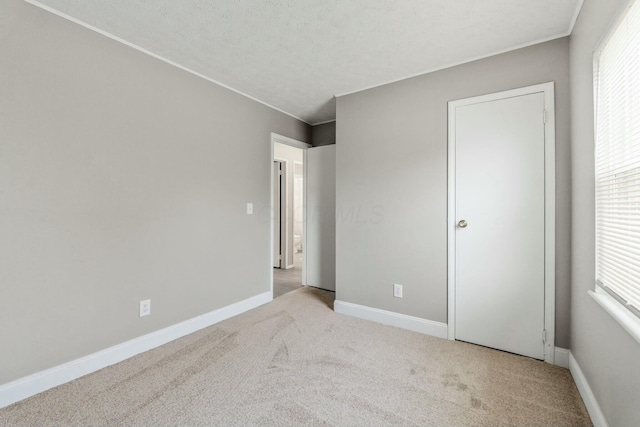 unfurnished bedroom featuring light carpet and a textured ceiling