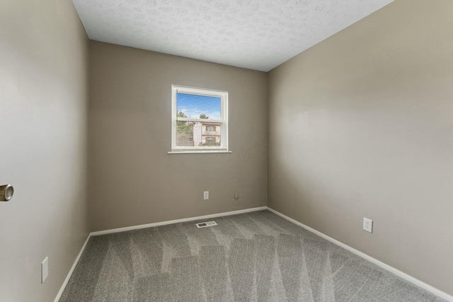 carpeted spare room with a textured ceiling