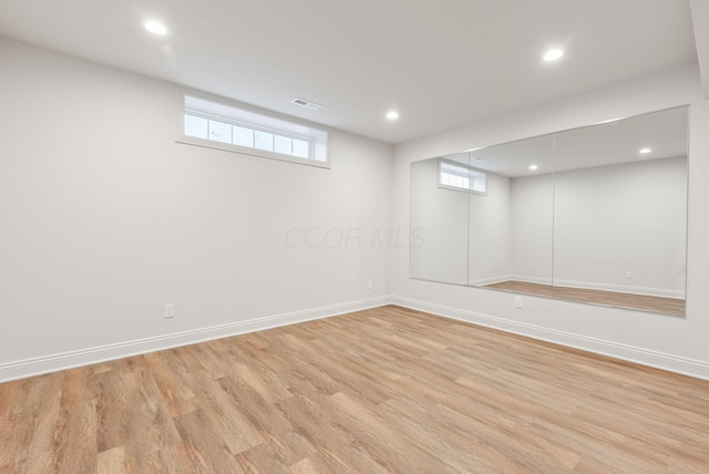 basement featuring recessed lighting, visible vents, light wood-style flooring, and baseboards