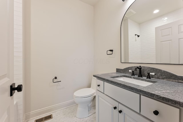 bathroom with visible vents, toilet, vanity, baseboards, and walk in shower