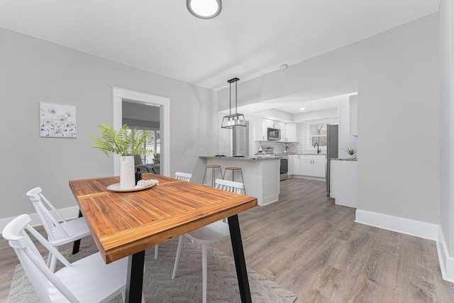 dining area with sink and light wood-type flooring