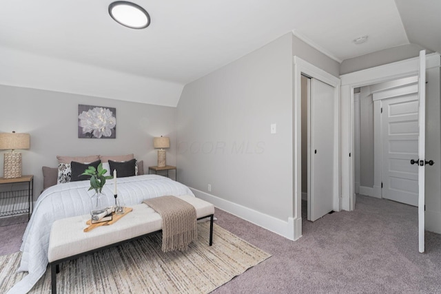 bedroom featuring a closet, light colored carpet, and vaulted ceiling