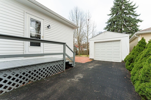 view of side of property featuring a wooden deck, an outdoor structure, and a garage