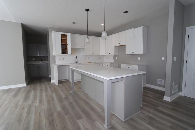 kitchen featuring white cabinets, light hardwood / wood-style flooring, and a center island