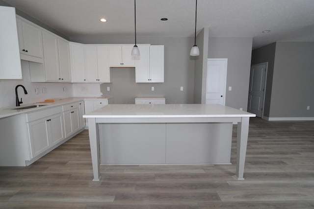 kitchen with sink, white cabinetry, and a kitchen island