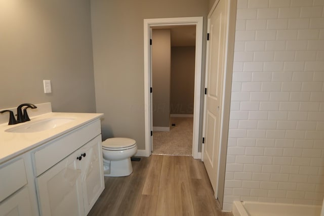 bathroom with hardwood / wood-style flooring, vanity, and toilet