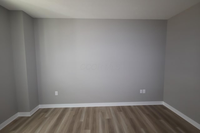 spare room with wood finished floors and baseboards