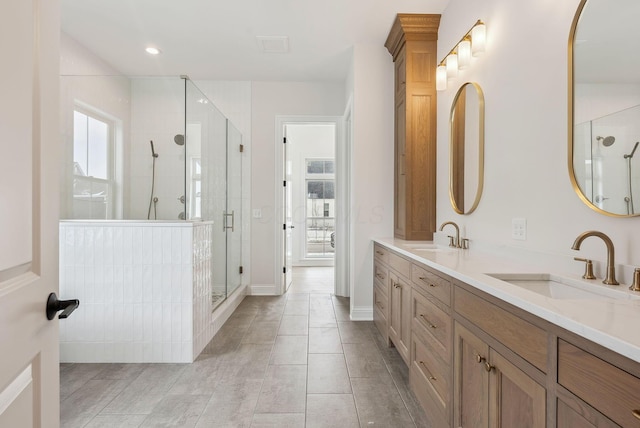 bathroom featuring a shower with door and vanity