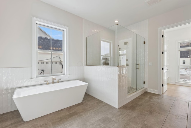 bathroom with independent shower and bath and tile walls